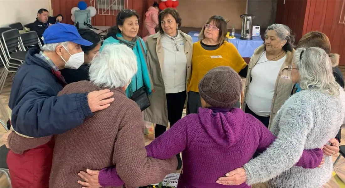 Un grupo de personas mayores abrazadas en ronda